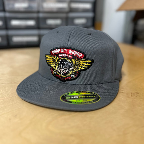 30th ANNIVERSARY CHARCOAL FLAT BILL FLEX FIT HAT WITH BRIGADE PATCH ON FRONT