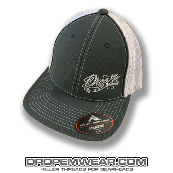 PACIFIC HEADWEAR CURVED BILL FITTED TRUCKER HAT GRAPHITE/WHITE WITH TATTOO SCRIPT LOGO ON LEFT PANEL