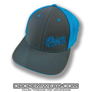 PACIFIC HEADWEAR CURVED BILL FITTED TRUCKER HAT NEON BLUE/GRAPHITE WITH TATTOO SCRIPT LOGO ON LEFT PANEL