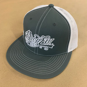 PACIFIC HEADWEAR FLAT BILL FITTED TRUCKER HAT GRAPHITE/WHITE WITH TATTOO SCRIPT LOGO ON LEFT PANEL
